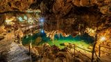 Der Blick in die beleutete Xkeken Cenote, in der sich türkisenes Wasser befindet