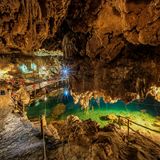 Der Blick in die beleutete Xkeken Cenote, in der sich türkisenes Wasser befindet