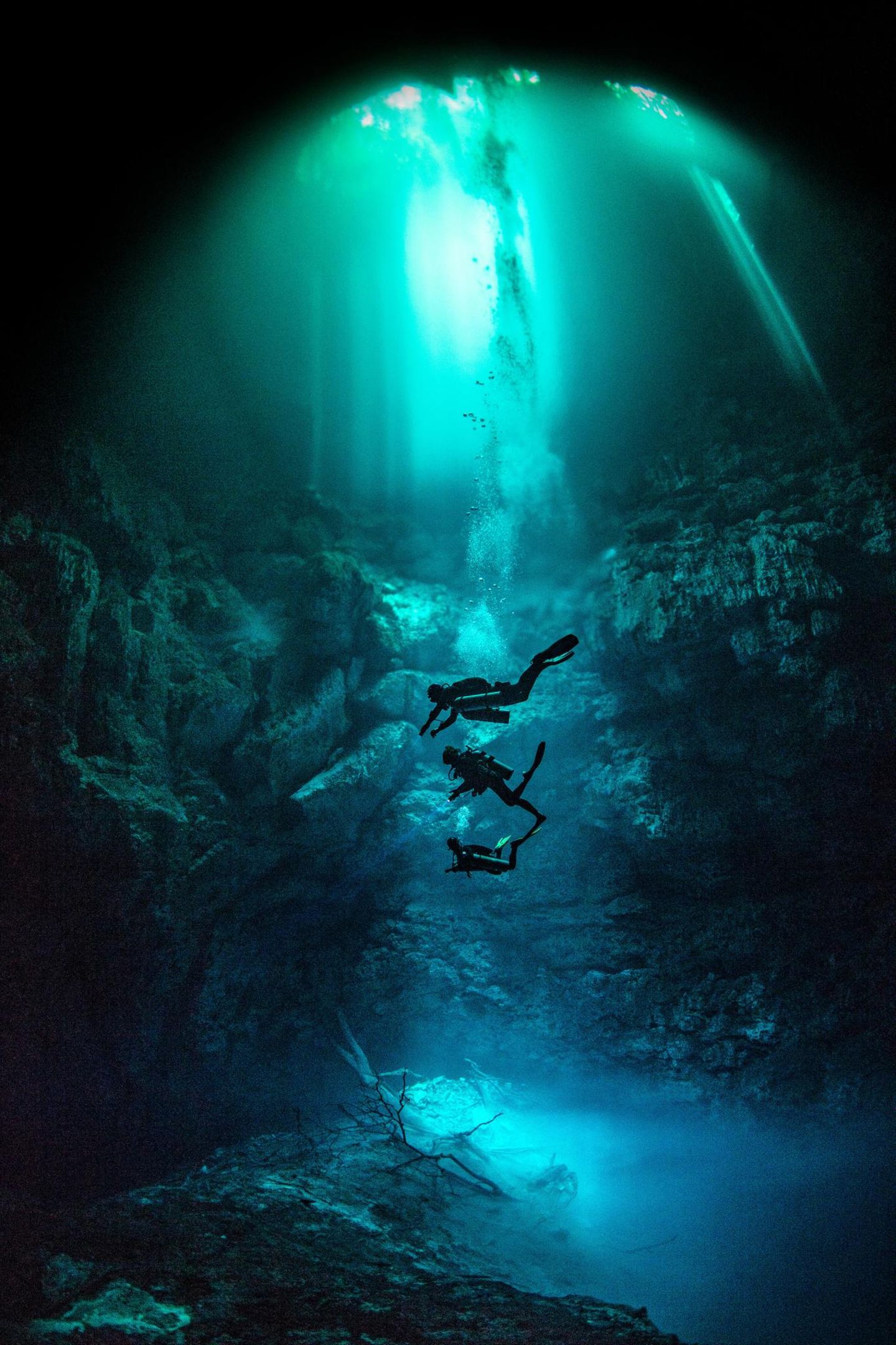 Tauchende Personen im Licht der Öffnung der Pit Cenote