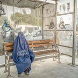 Eine Frau wartet 2020 an einer Kabuler Bushaltestelle