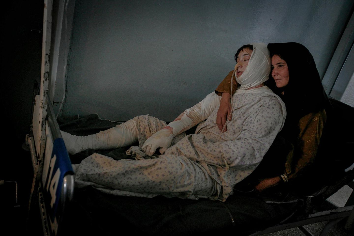 Frau hält verwundete Frau auf Krankenbett