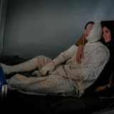 Frau hält verwundete Frau auf Krankenbett