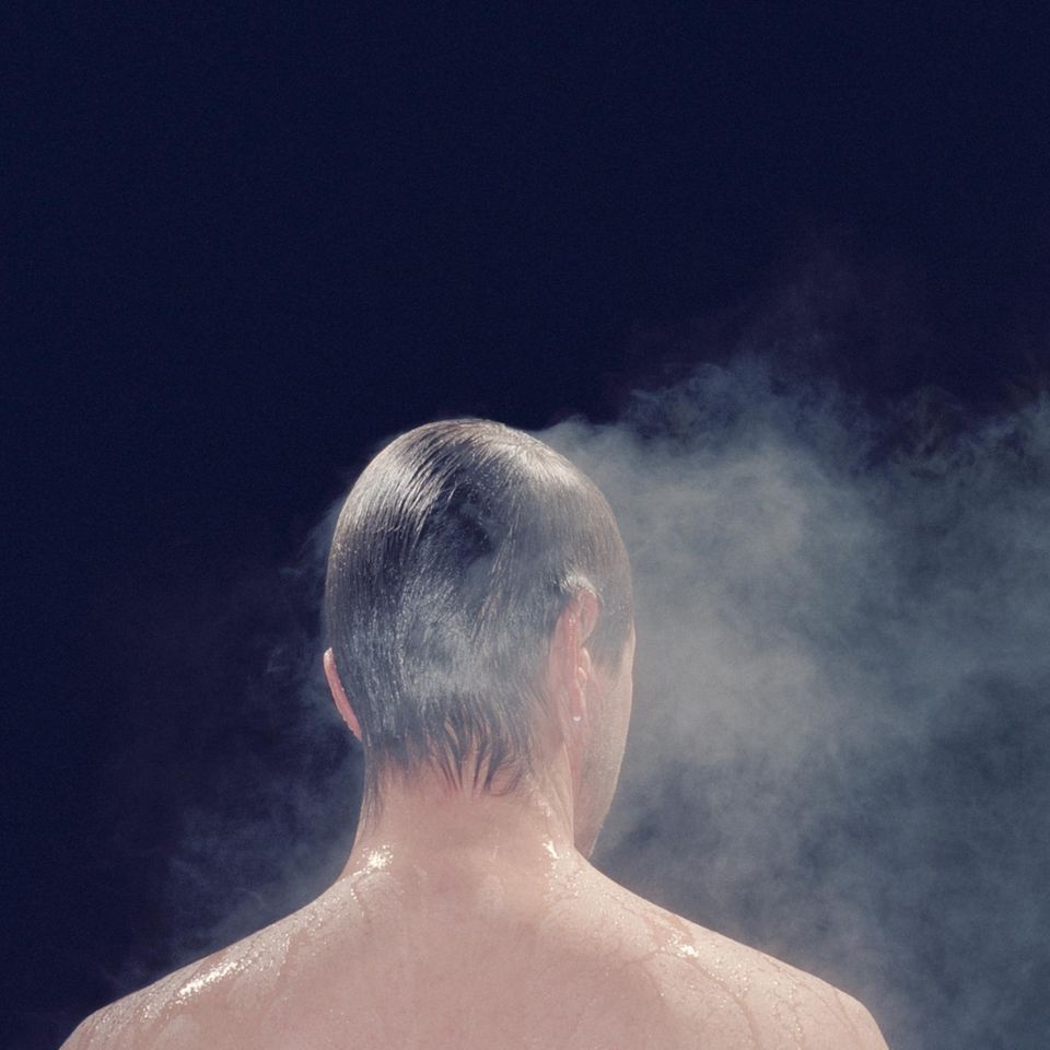 Dampf steigt vom Körper eines Mannes auf  Dampf steigt vom Körper eines Mannes auf