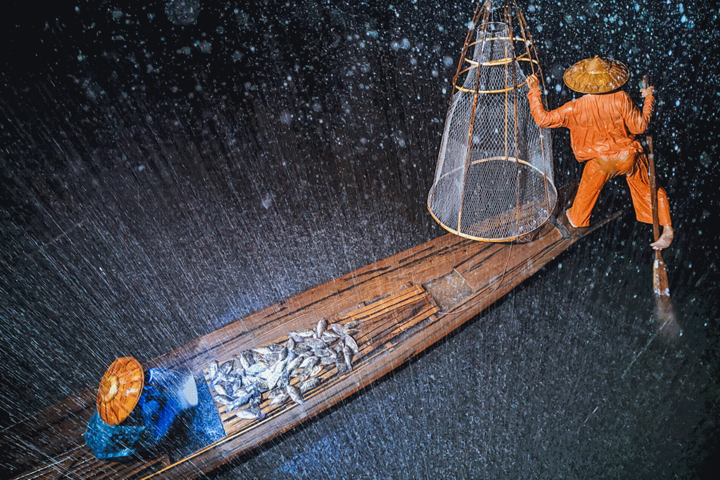 Im strömenden Regen Während eines Regenschauers Fischer paddeln auf einem Boot über den Inle-See