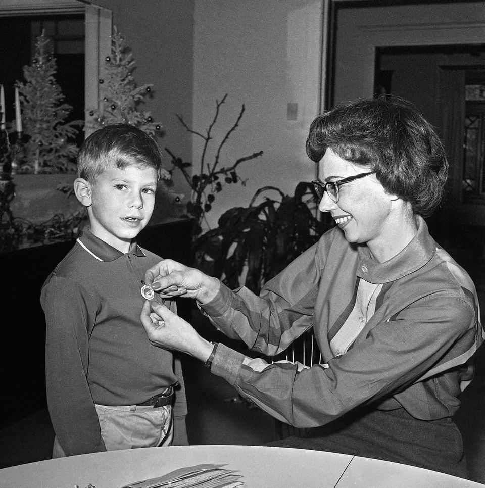 Ein kleiner Junge erhält den Button mit der Aufschrift : Ich habe einen Zahn für die Wissenschaft gespendet