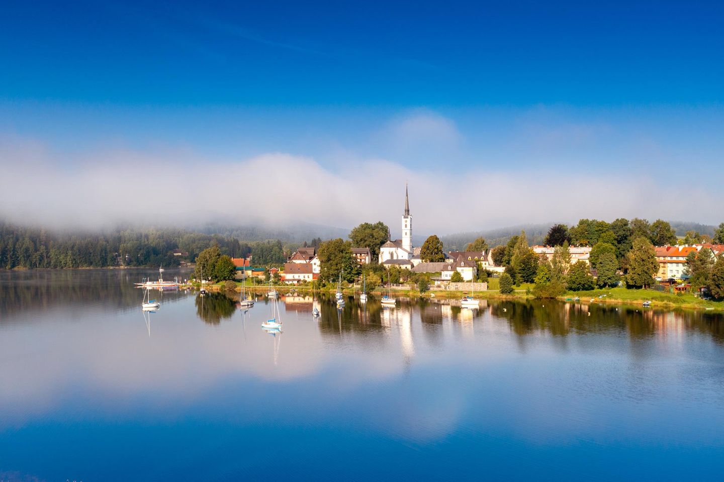 Der Lipnosee, in dem sich sowohl der Kirchturm, als auch der blaue Himmel spiegeln
