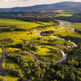 Der Flusslauf der Moldau durch grüne Wiesen und Wälder