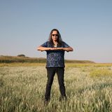 Ein Mann steht mit aufeinandergelegten Handflächen in einem Feld