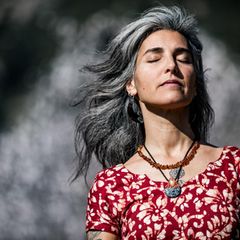 Eine attraktive Frau mit grauen Haaren und geschlossenen Augen