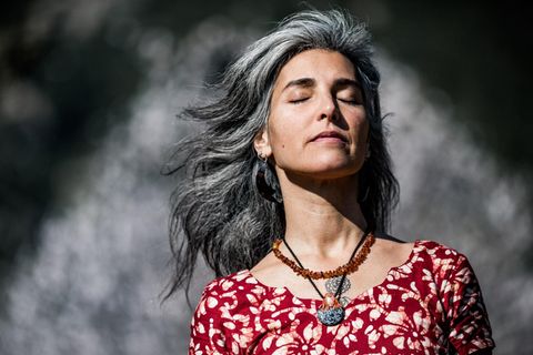 Eine attraktive Frau mit grauen Haaren und geschlossenen Augen