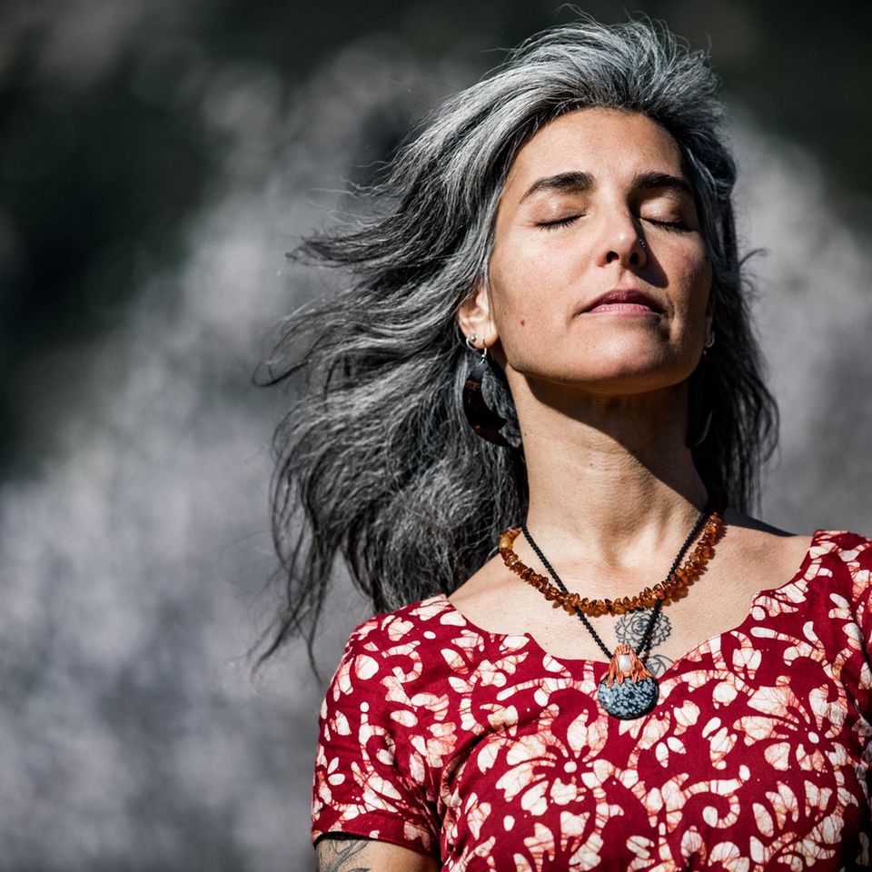 Eine attraktive Frau mit grauen Haaren und geschlossenen Augen