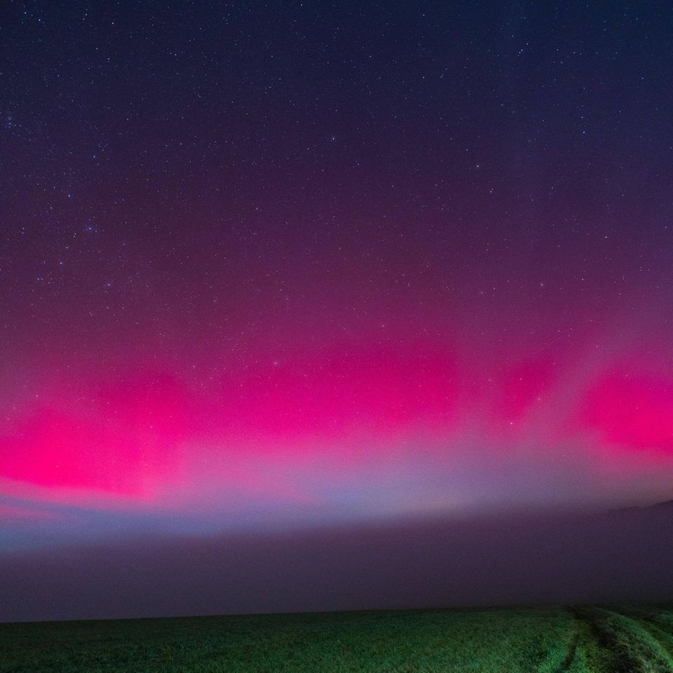 Treffen Sonnenteilchen auf die Erdatmosphäre, regen sie in hohen Schichten Gasmoleküle zum Leuchten an: Stickstoff strahlt blau oder violett, Sauerstoff rötlich, in niedrigen Höhen auch grün. Als im November 2025 Polarlichter selbst über Bayern am Nachthimmel tanzen, steckt hinter dem Spektakel ein heftiger Sonnensturm