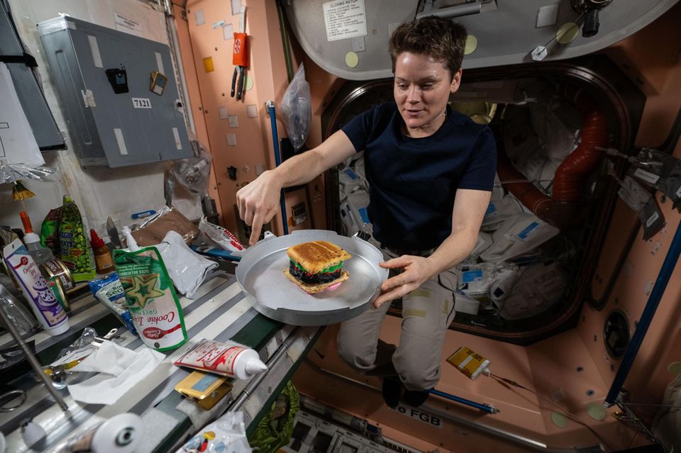 Anne McClain mit einem Kuchen auf der ISS