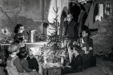 Familie sitzt um einen Weihnachtsbaum