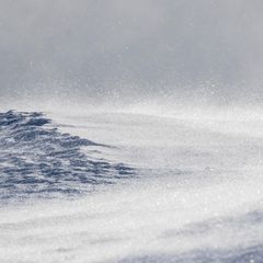 Ein Schneesturm peitscht über eine Bergkuppe