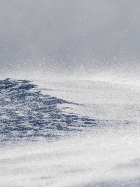 Ein Schneesturm peitscht über eine Bergkuppe