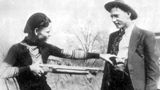 Bonnie bedroht Clyde spielerisch mit einem Gewehr