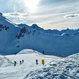 Schneebedeckte Berge und Personen, die Ski fahren