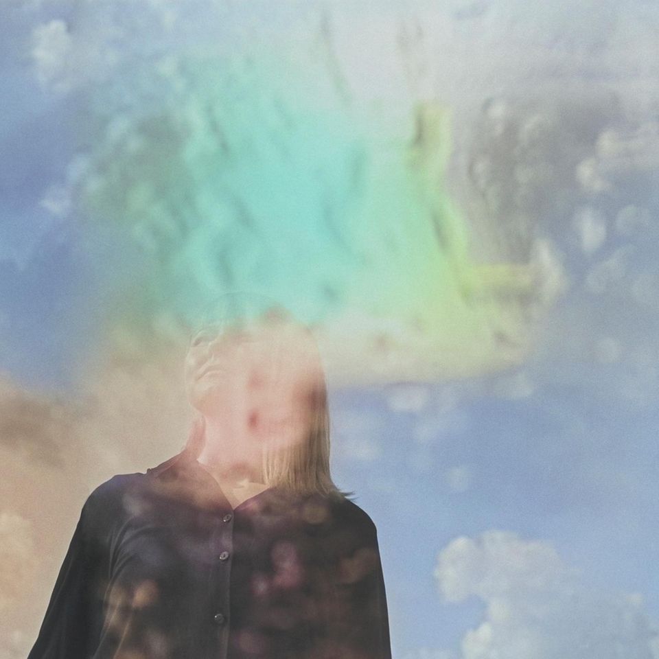 Künstlerisches Bild mit Mehrfachbelichtung – eine Frau schaut träumerisch in die Ferne