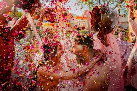 Zwei Menschen werden bei ihrer Hochzeit mit Blüten und Wasser überschüttet
