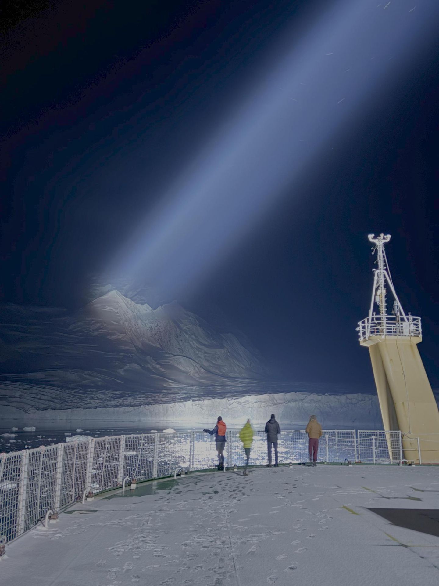Ein Scheinwerferstrahl beleuchtet einen Gletscher in der Dunkelheit