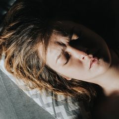 Frau mit geschlossenen Augen auf einem Kissen