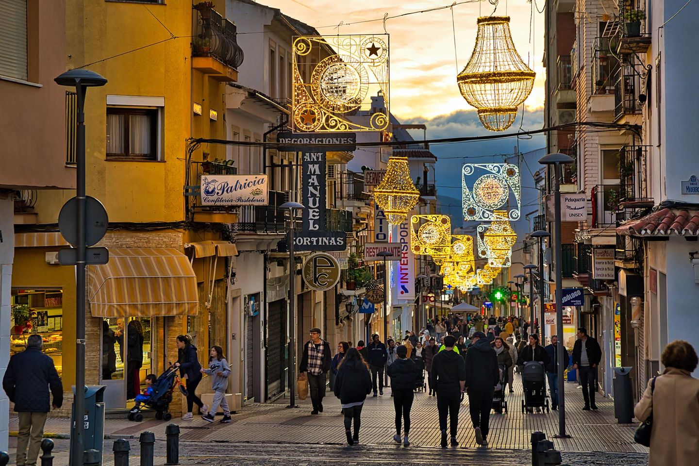 Straße mit Menschen, Läden und Weihnachtsbeleuchtung