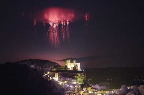 Rote Kobolde am Nachthimmel über Burg Beynac