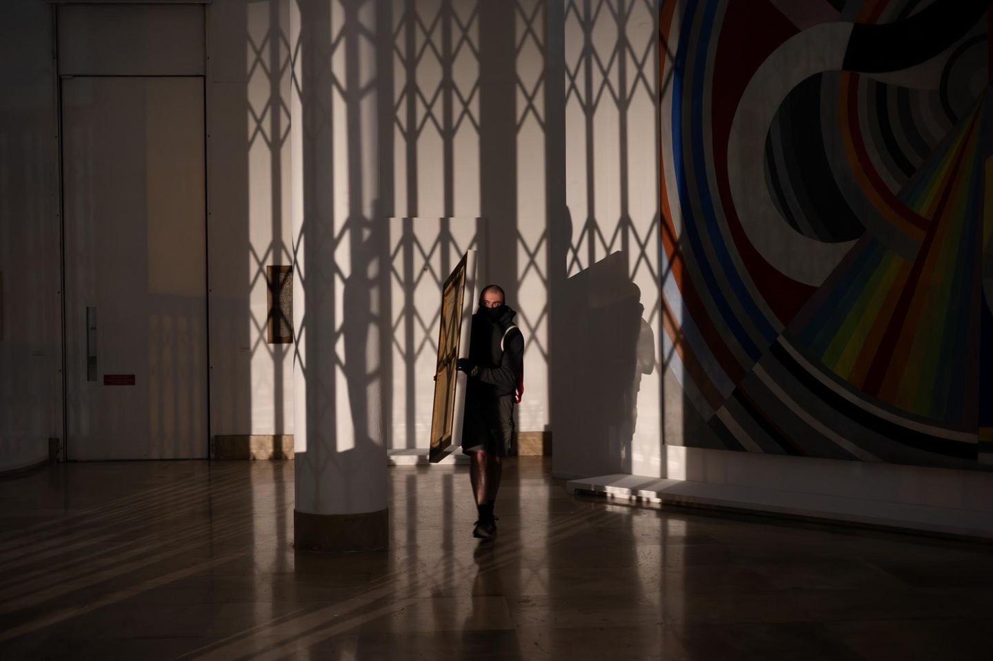 Mann trägt Gemälde aus Gebäude