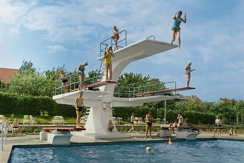 Personen springen von einem Sprungturm im Freibad
