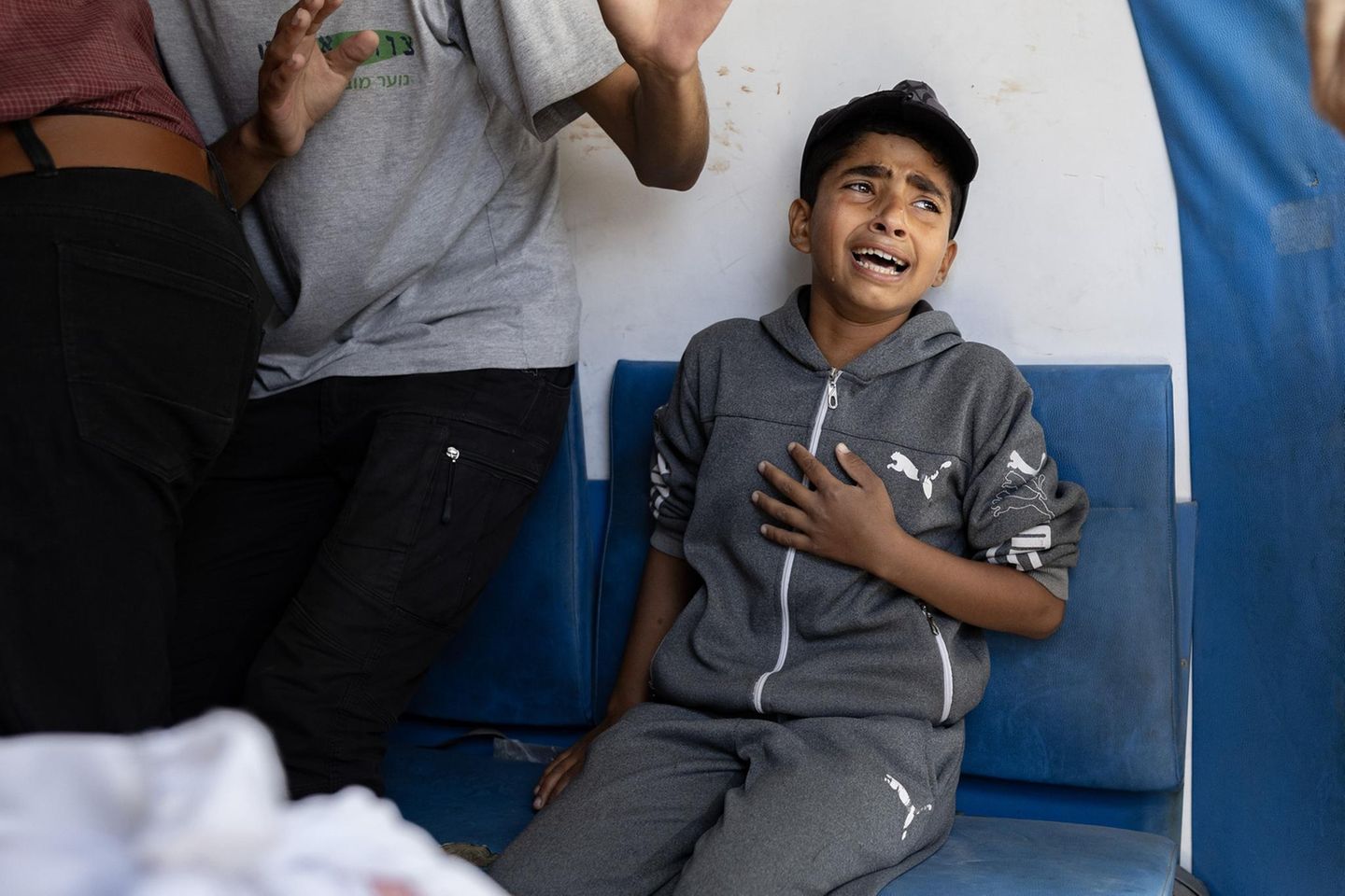 Ein Junge hält sich die Hand an die Brust, er weint