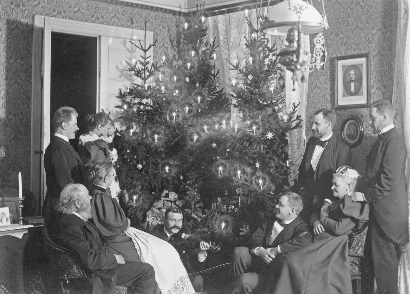 Familie posiert um Weihnachtsbaum
