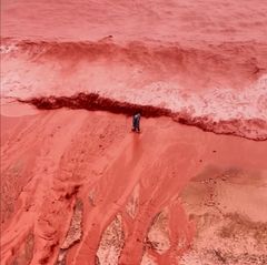 This picture, taken from video, shows how rainfall briefly transforms the coastline of its famed Red Beach into a striking natural scene on Iran's Hormuz Island, Tuesday Dec. 16, 2025