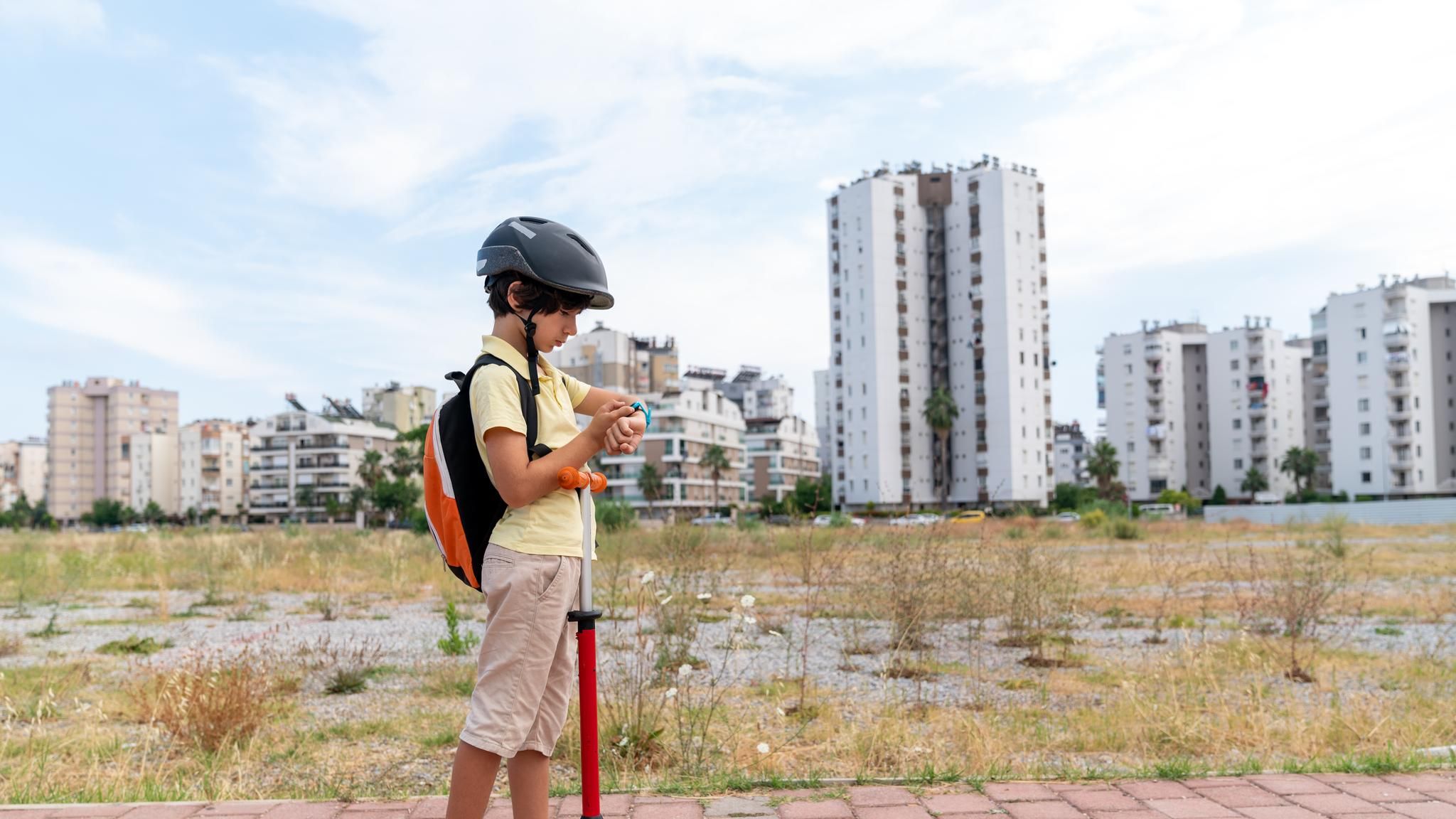 Junge mit Roller auf dem Weg zur Schule