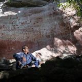 Victor Calcedo posiert vor der Felskunst in La Serrania de La Lindosa Guaviare in Kolumbien