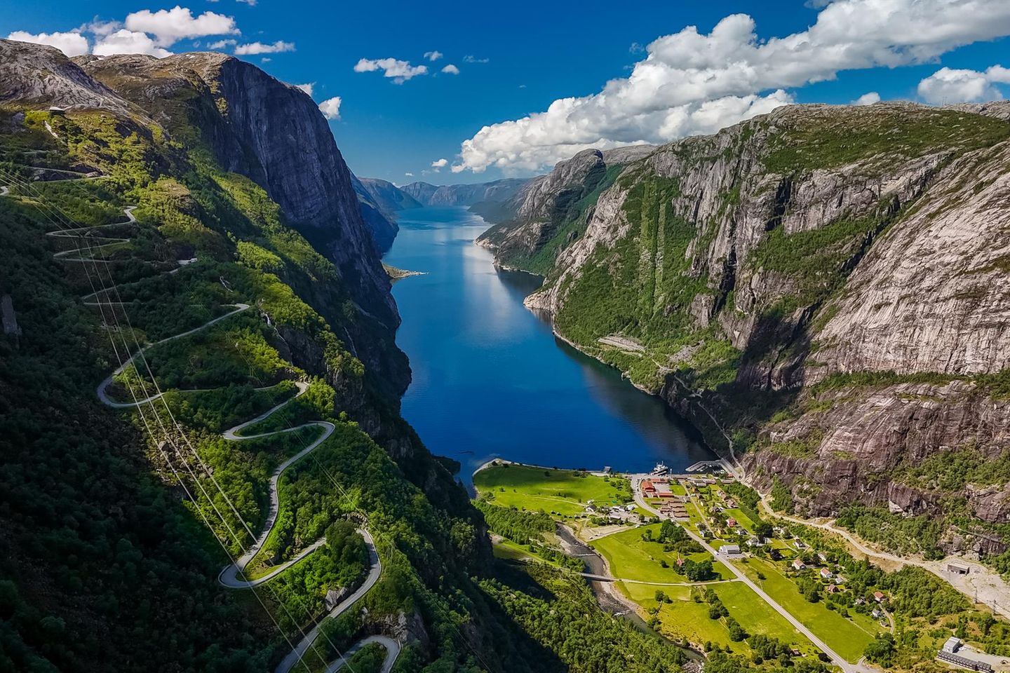 Nur 45 Minuten östlich von Stavanger wartet eine der eindrucksvollsten Landschaften Norwegens: Der 42 Kilometer lange und bis zu 500 Meter tiefe Lysefjord liegt wie ein blau glitzerndes Band zwischen steilen Granitwänden und majestätischen Gipfeln. Am Ende des Fjords schmiegt sich das winzige Dorf Lysebotn ans Ufer. Jahrzehntelang war es nur per Boot erreichbar, und noch heute zählt es kaum mehr als zehn feste Einwohner. Doch im Sommer verwandelt sich der Ort in ein quirliges Basislager für Camper, Wanderer und Abenteurer. Ob auf dem Campingplatz Kjerag Lysebotn, bei Kaffee und Zimtschnecken im Dorfcafé oder nach einem schnellen Besuch im Dorfladen: Hier beginnt für viele die Erkundungstour durch das Herz des Fjords. Neben der beliebten Tour zum Preikestolen lockt auch der Kjeragbolten, ein Felsblock, der schwindelerregend zwischen zwei Wänden eingeklemmt über dem Fjord schwebt. Sportliche erklimmen die 4.444 Holzstufen der Flørlitrappene und gönnen sich zum Schluss im alten Kraftwerkscafé des straßenlosen Dorfs Flørli ein Stück Kuchen. Genug gewandert und geklettert? Dann lohnt sich ein Perspektivwechsel. Schließlich lassen sich die majestätischen Felswände auch vom Wasser aus erkunden, etwa bei einer Kajaktour, einer Fährfahrt oder einer Tageskreuzfahrt.