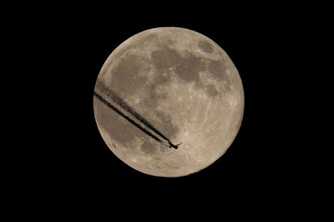 Flugzeugsilhouette vor Mond