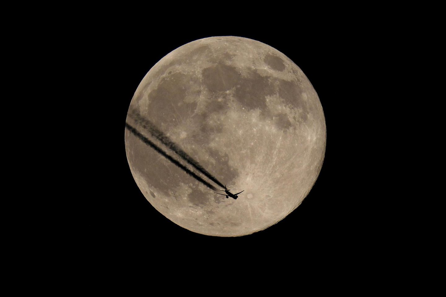 Flugzeugsilhouette vor Mond