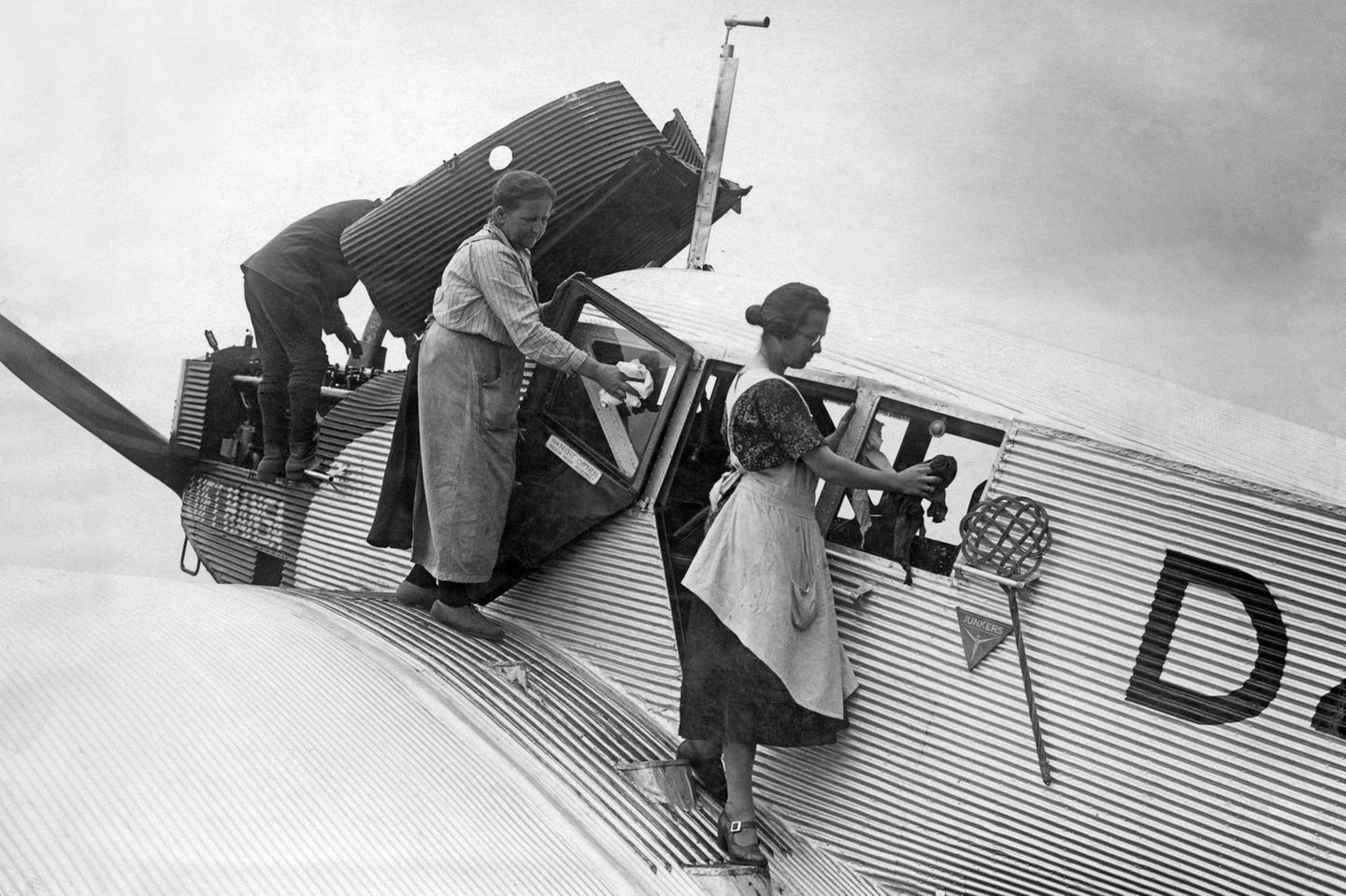 Zwei Frauen stehen auf der Tragfläche einer Junkers im Dienst der Luft Hansa, und polieren die Scheiben, 1920er Jahre