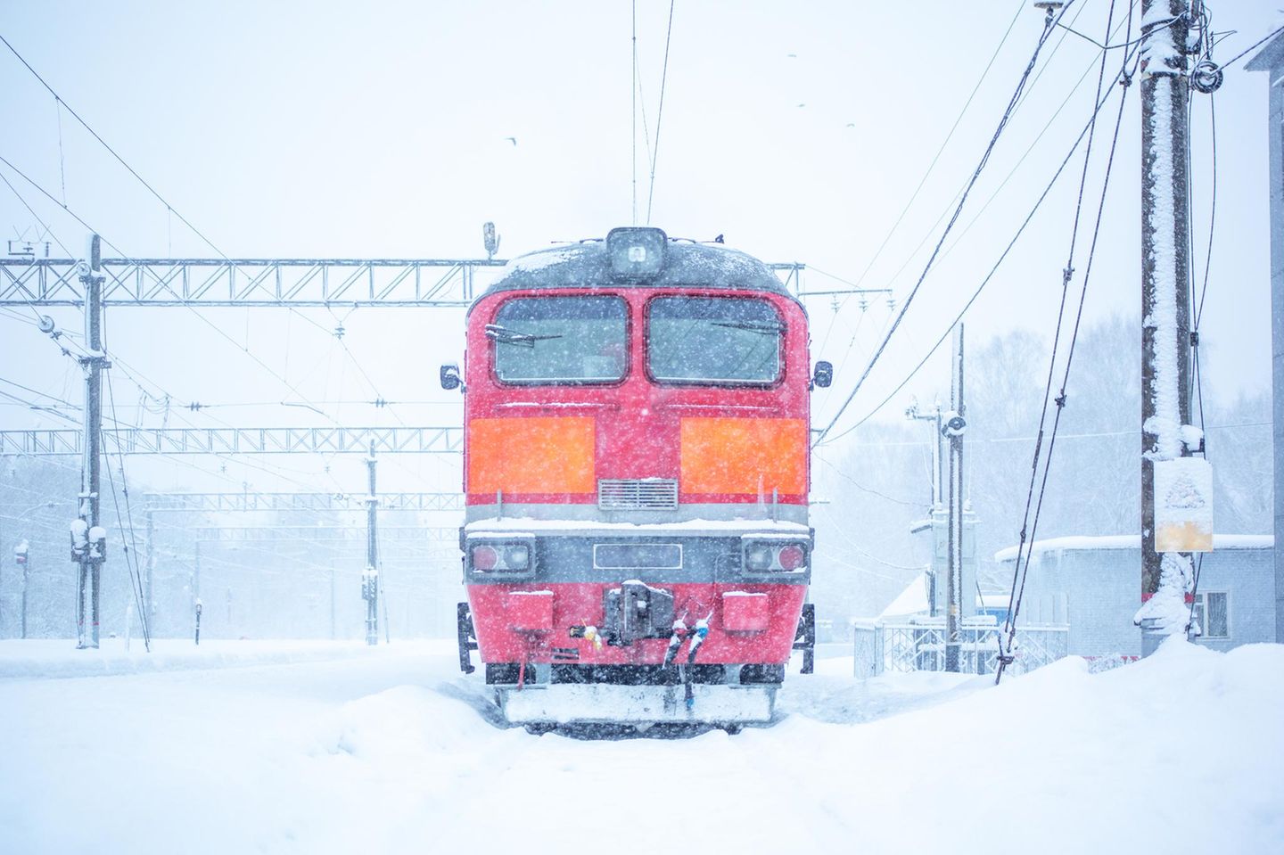 Rote Lokomotive auf schneeverdeckten Gleisen