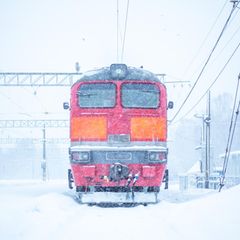Rote Lokomotive auf schneeverdeckten Gleisen