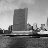 Schwarz-weiß Fotografie eines rechteckigen Wolkenkratzers am Flussufer von Manhattan, 1950er Jahre