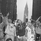 Sechs nordamerikanische Indigene in traditioneller Kleidung, die vor der Kulisse Manhattans in die Höhe schauen; sw-Foto; 1949