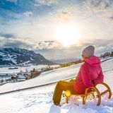 Frau rodelt im Allgäu