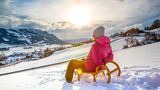 Frau rodelt im Allgäu