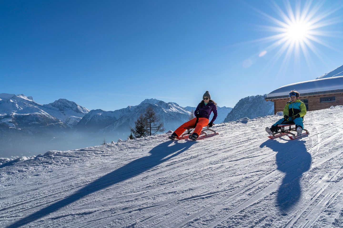 Walliser Alpen mit einer Mutter und ihrem Sohn auf Schlitten