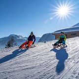 Walliser Alpen mit einer Mutter und ihrem Sohn auf Schlitten