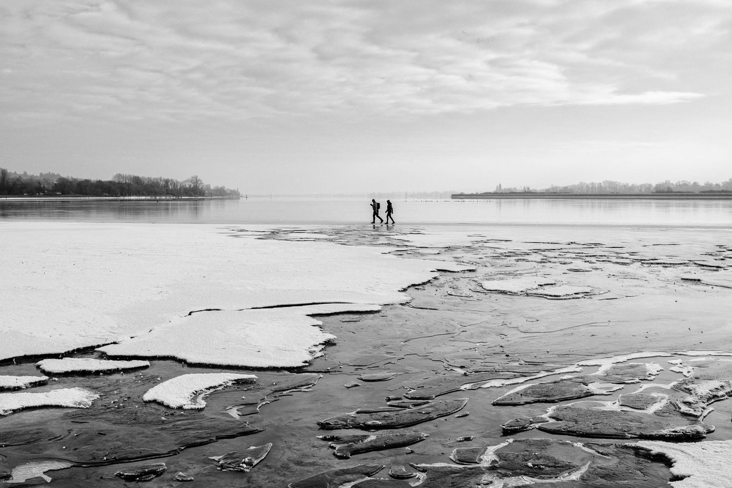 Zwei Menschen gehen auf zugefrorenem Bodensee spazieren