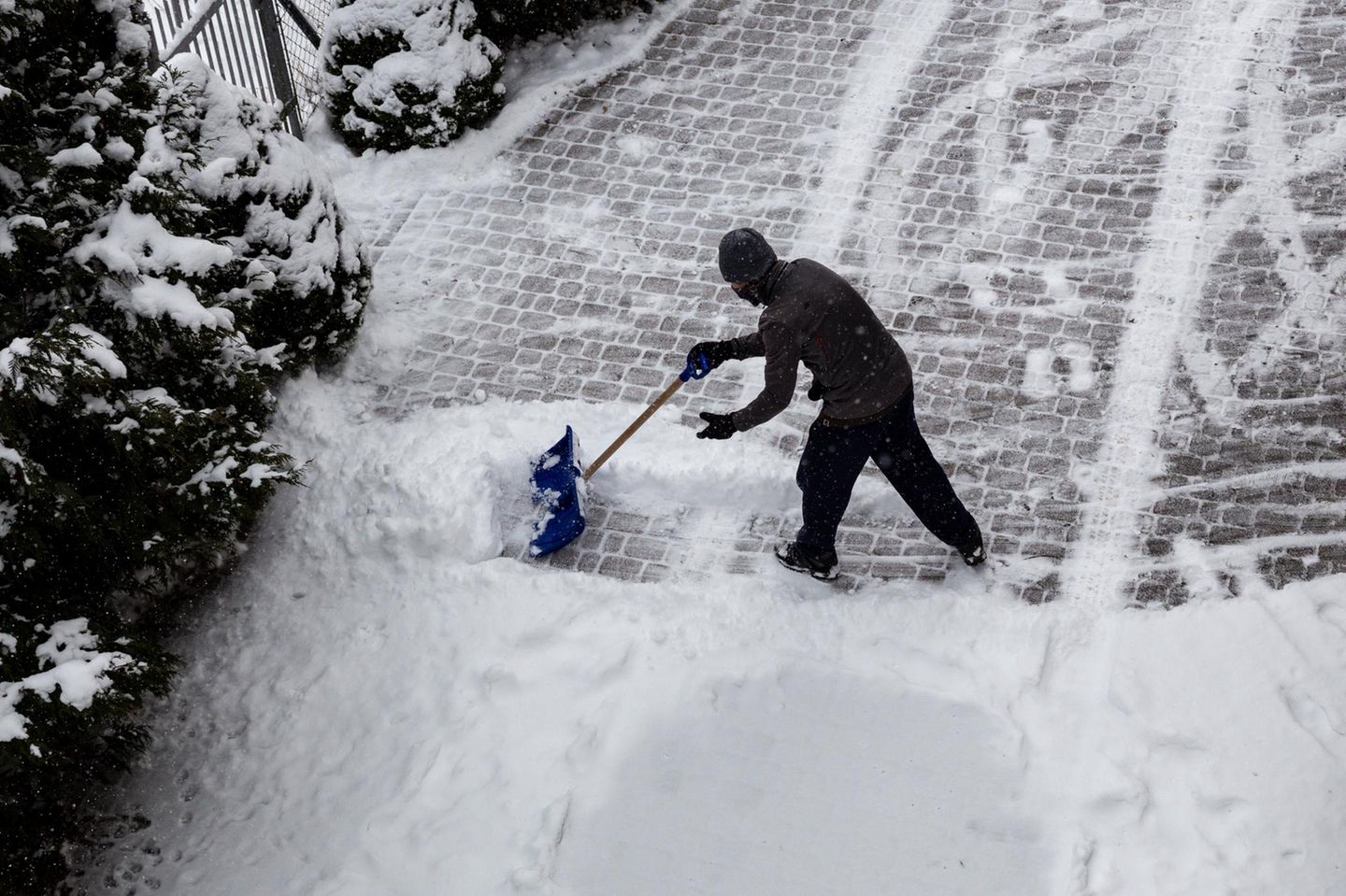 Ein Mann schaufelt Schnee