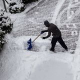 Ein Mann schaufelt Schnee